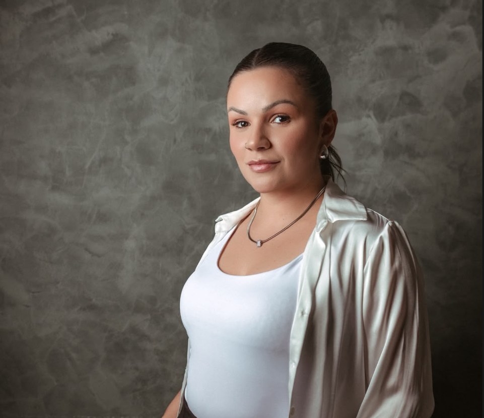 Layane Dola em retrato de estúdio, camisa de cetim e fundo cinza